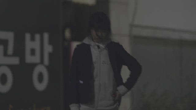 Student walking down the street at night with a tired expression
