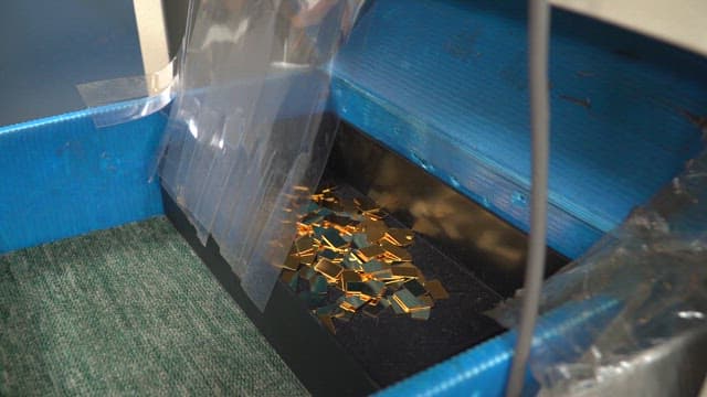 Small metal pieces in a blue container