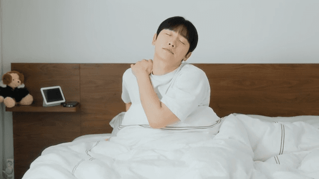 Man waking up and checking phone in bed