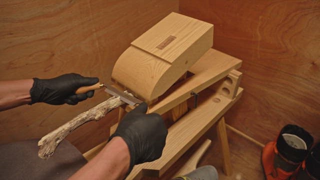Wood carving with a hand tool indoors
