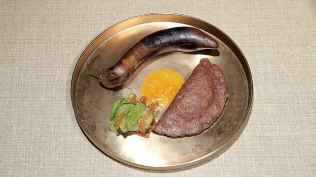 Meat dumplings and roasted eggplant served in a brass plate