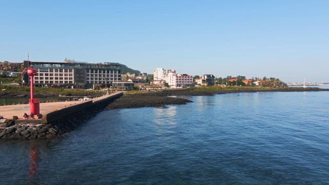 Coastal cityscape with a red lighthouse