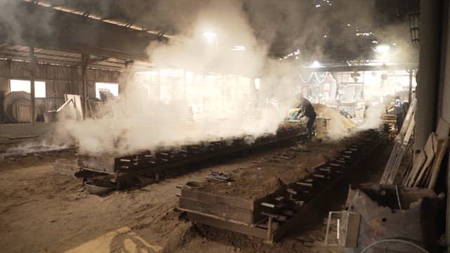 Workers in a smoky factory environment