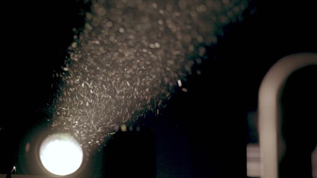 Dust particles floating in the air illuminated by a bright light