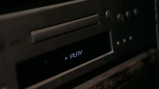 DVD player display with the "Play" button highlighted in a dimly lit room.