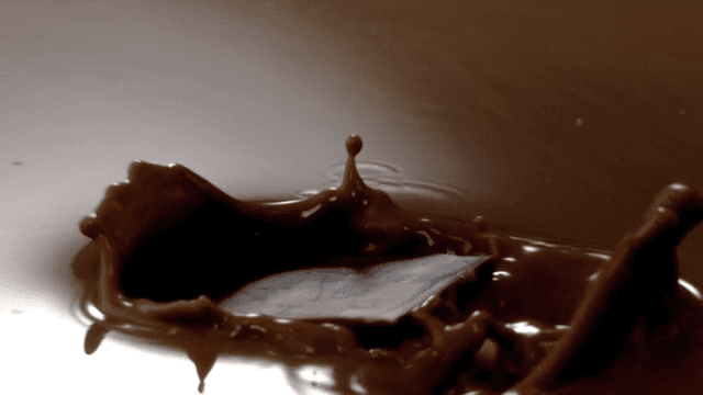 Chocolate pieces falling into chocolate fondue