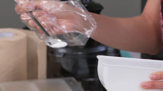 Adding Flour to a Glass Bowl Full of Potatos