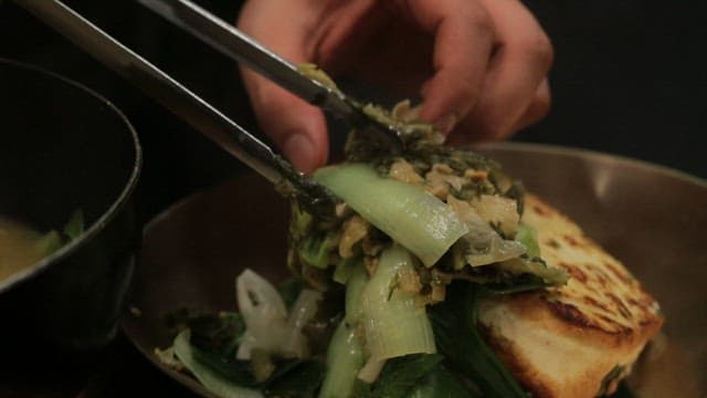 Fermented kimchi plated next to braised tofu
