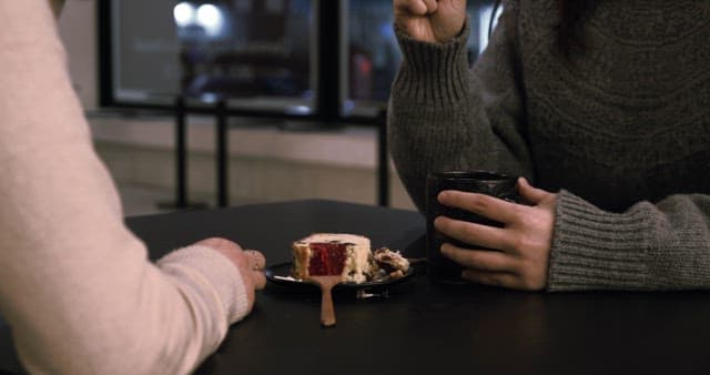 Two People Sharing Dessert and Coffee at Cafe