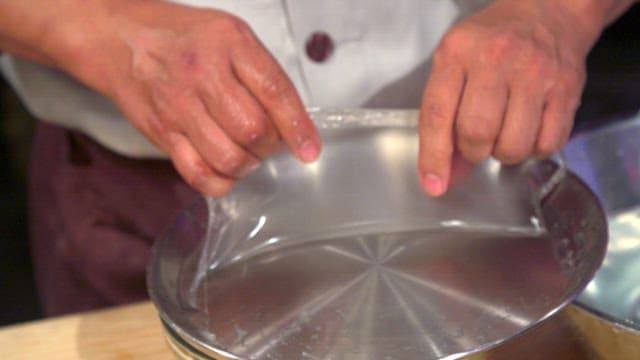 Chef removing cooked starch batter from a tray