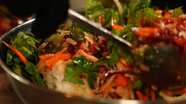 Yukhoe bibimbap with fresh vegetables in a large bowl