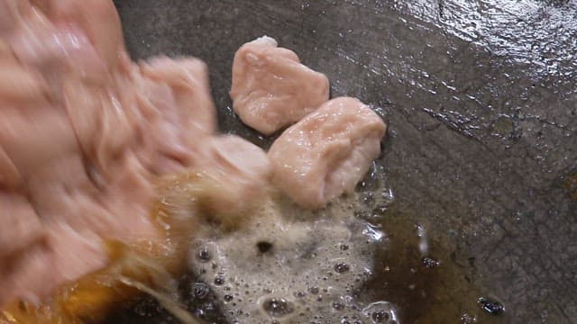 Grilled pork intestines sizzling in oil on a hot pan