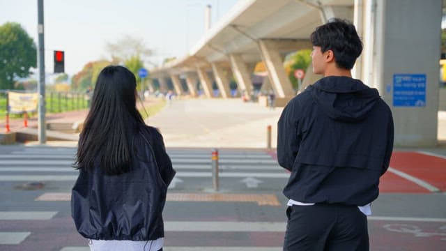 People warming up while waiting at the crosswalk