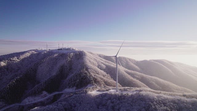 Wind Generators on Misty and Snowy Mountain in the Morning