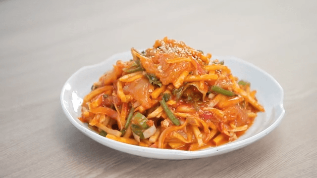Plate of mixed cold raw fish soup on a wooden table