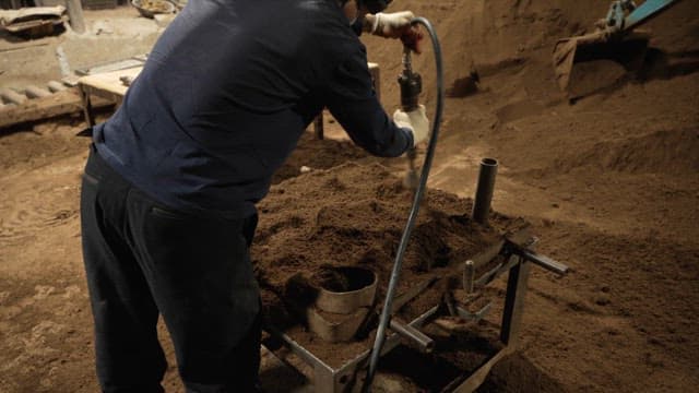 Worker shaping sand in a workshop