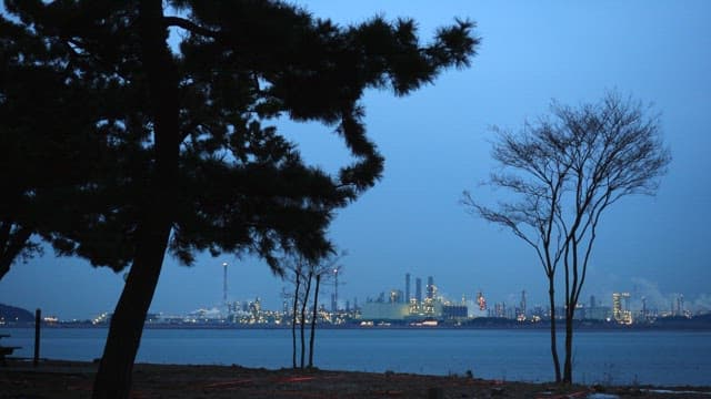 Dusk by the sea with a view of the industrial city