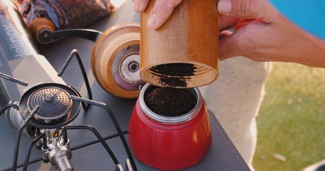 Preparing coffee outdoors with a manual grinder