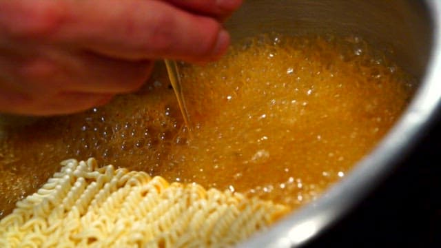 Cooking ramen with an egg in a pot