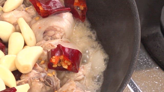 Cooking chicken with garlic and red chili