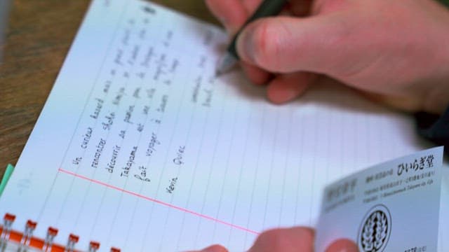 Person writing postcards or notes in French