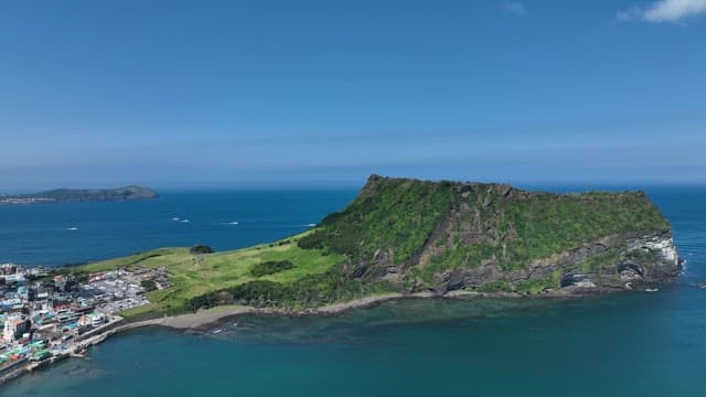 Seongsan Ilchulbong with Lush Greenery and Serene Sea on a Sunny Day