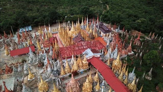 Inn Dein historic site filled with Buddhist statues amidst dense forests