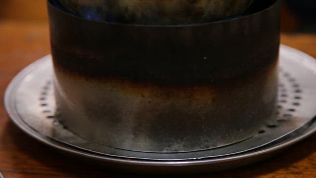 Soup with tofu boiling in a pot on a brazier