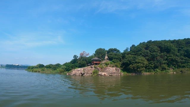Island with a pavilion surrounded by greenery and water
