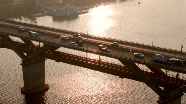 Vehicles crossing a bridge at sunset