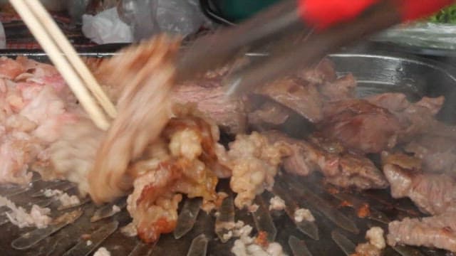 Beef brisket grilled with chopsticks on a grill