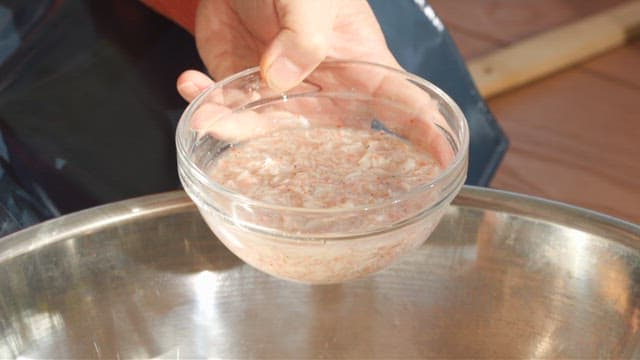 Salted shrimp added to a metal basin containing ingredients