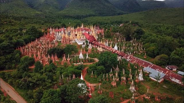 Inn Dein historic site filled with Buddhist statues amidst dense forests