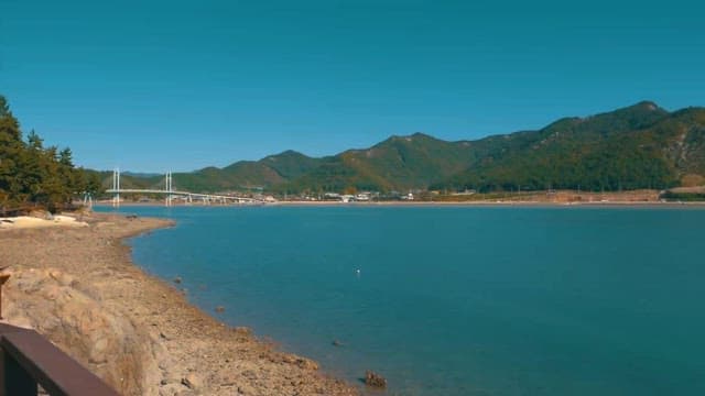 Serene Coastal Landscape with Bridge and Mountains