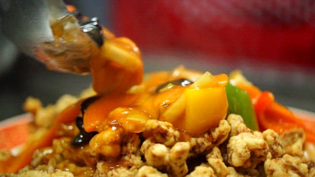 Crispy sweet and sour pork drizzled with sauce