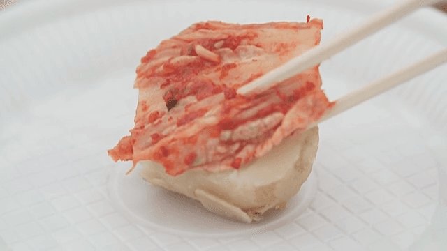 Placing Spicy Kimchi on a Boiled Potato with Chopsticks