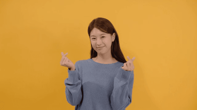 Woman giving finger hearts with happy expression