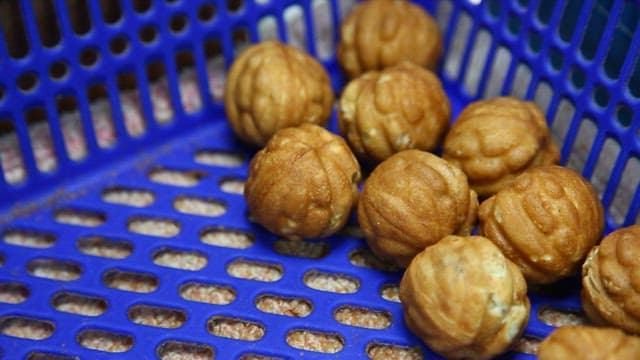 Walnut cakes in a blue plastic container
