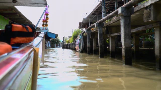 Midday boat ride through the canals of a small town with floating home 