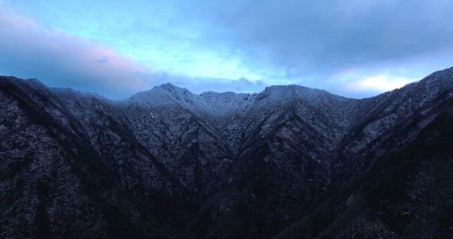 Snow-covered mountains under cloudy skies