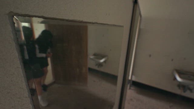 Reflection of a Students in a Worn Mirror