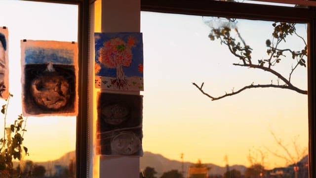 Art on display at a window during sunset