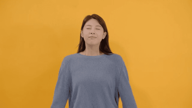 Long-haired woman smiling with her eyes closed, enjoying the leisure time