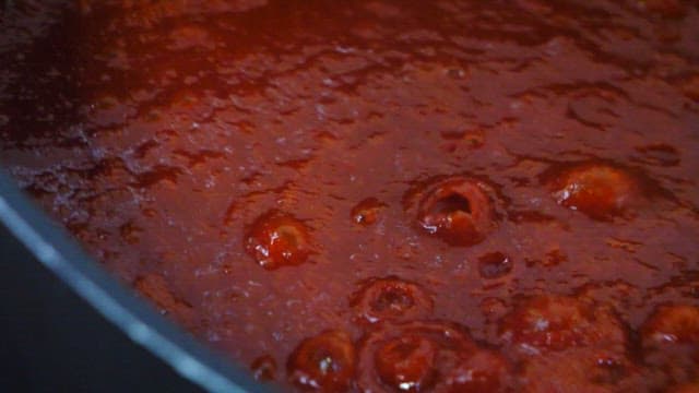 Boiling red sauce being stirred