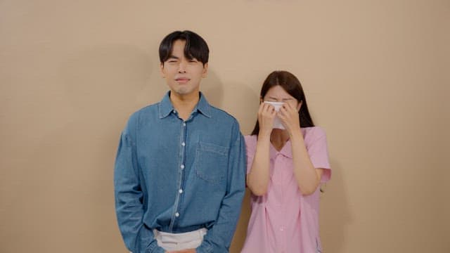 Man and a woman expressing their sadness by crying and wiping away tears