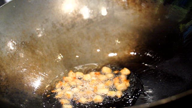 Adding the chunjang sauce to the wok with stir-fried lard pieces