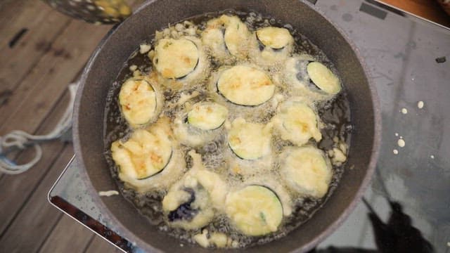 Slices of eggplant frying in hot oil