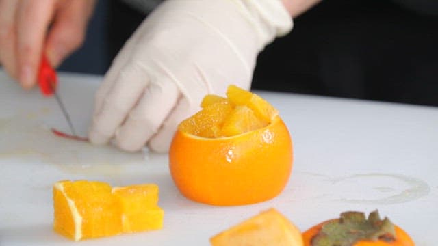 Preparing a fruit dessert with oranges and cherries