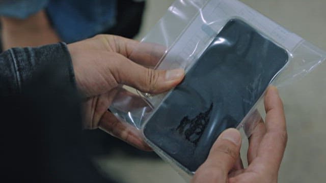 Person Forcibly Unlocking a Cell Phone