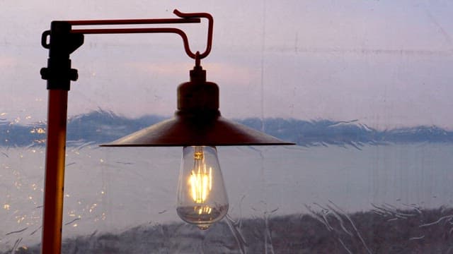 Glowing lamp against the backdrop of a tranquil scene outside the window